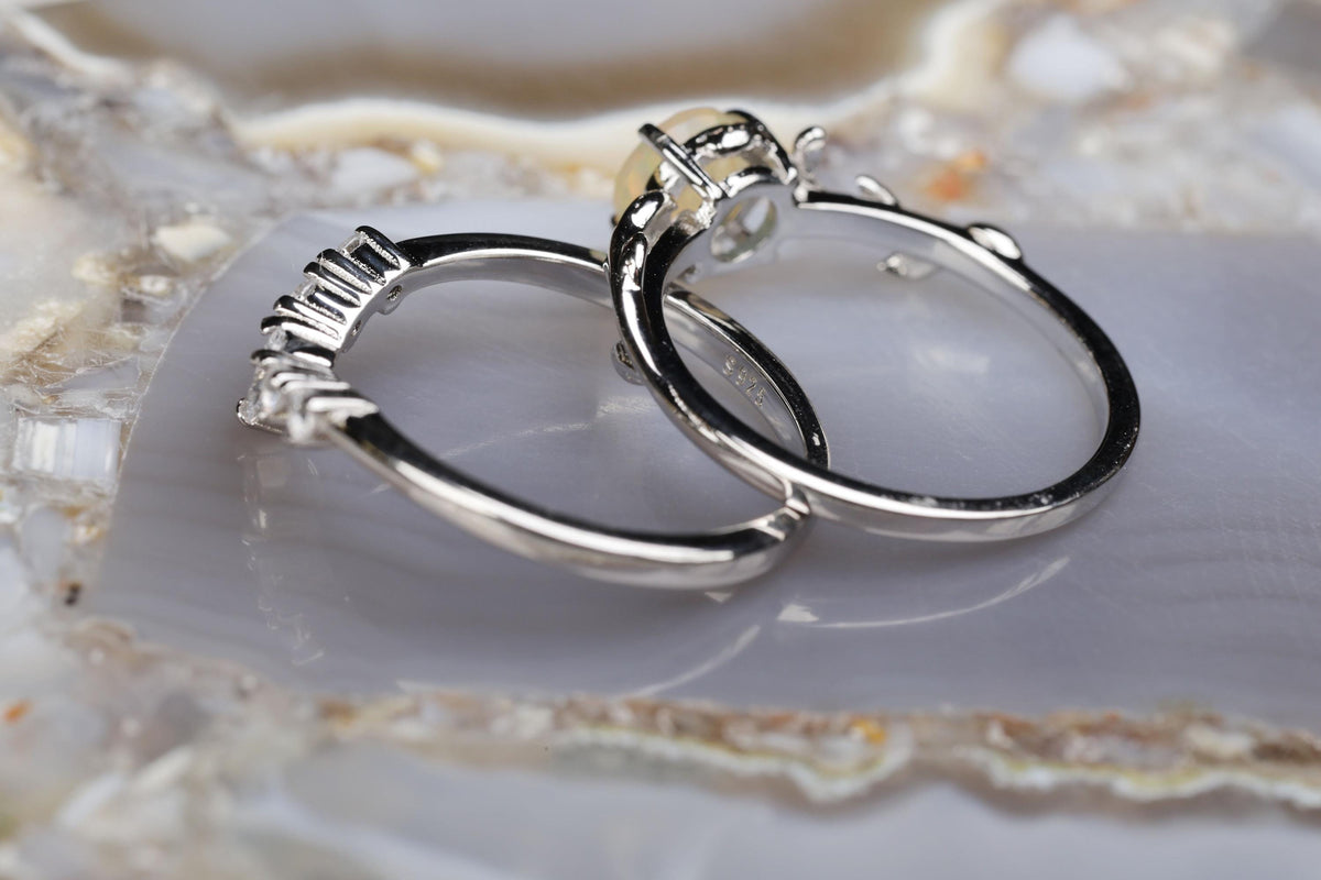 a couple of silver rings sitting on top of a rock
