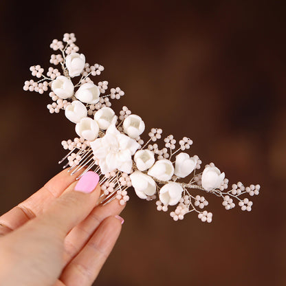 a hand holding a hair comb with flowers on it