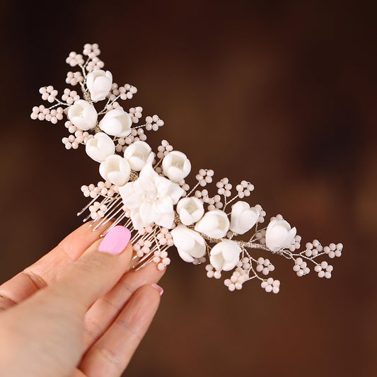 a hand holding a hair comb with flowers on it