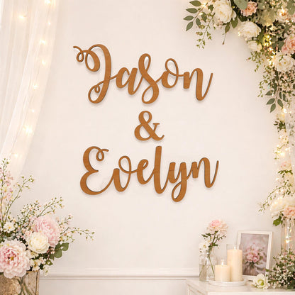a wall with a large wooden sign that reads "JASON & EVELYN", surrounded by floral decorations and candles.