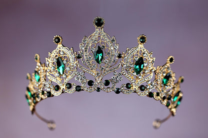a tiara with emeralds and diamonds on a purple background