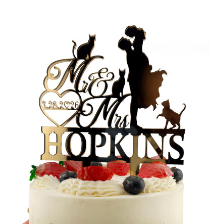 A wedding cake with a black silhouette of a bride and groom on top, along with the names "Mrs Hopkins" and a date "3.28.20".