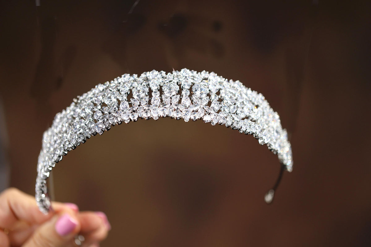 a close up of a person holding a tiara