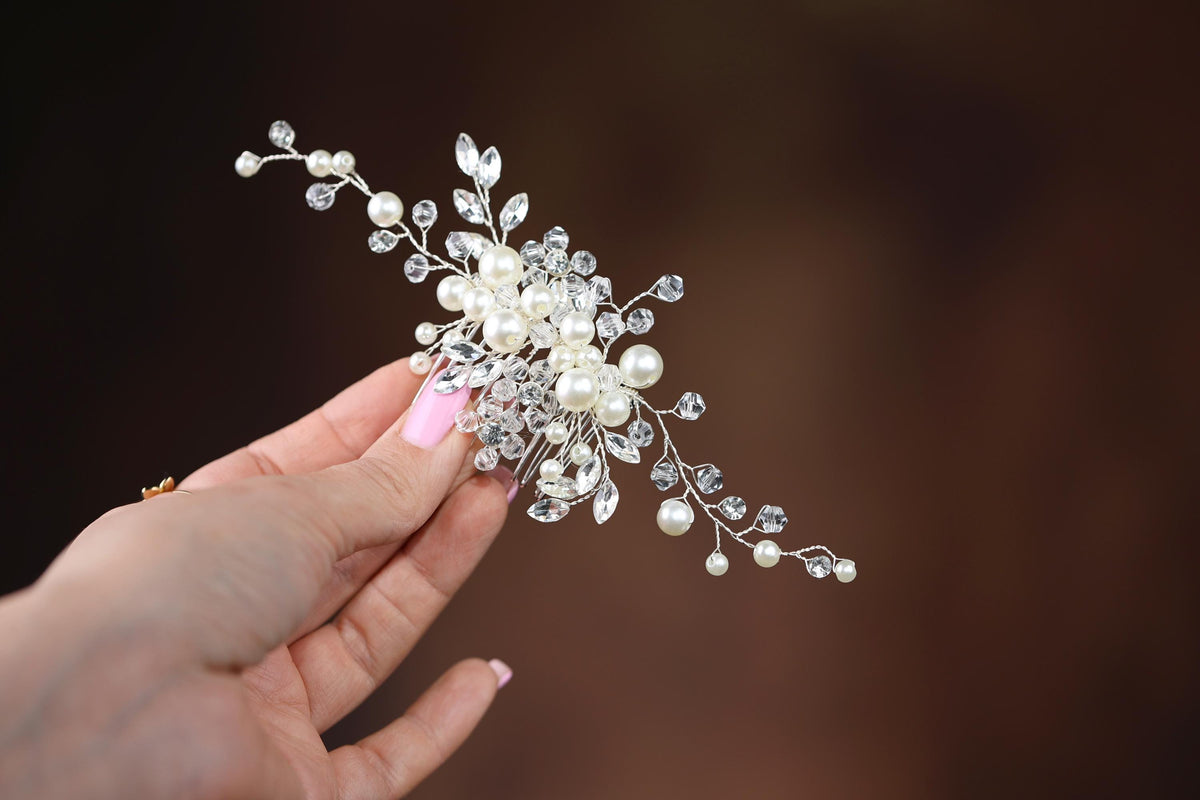 a woman is holding a crystal and pearl hair comb