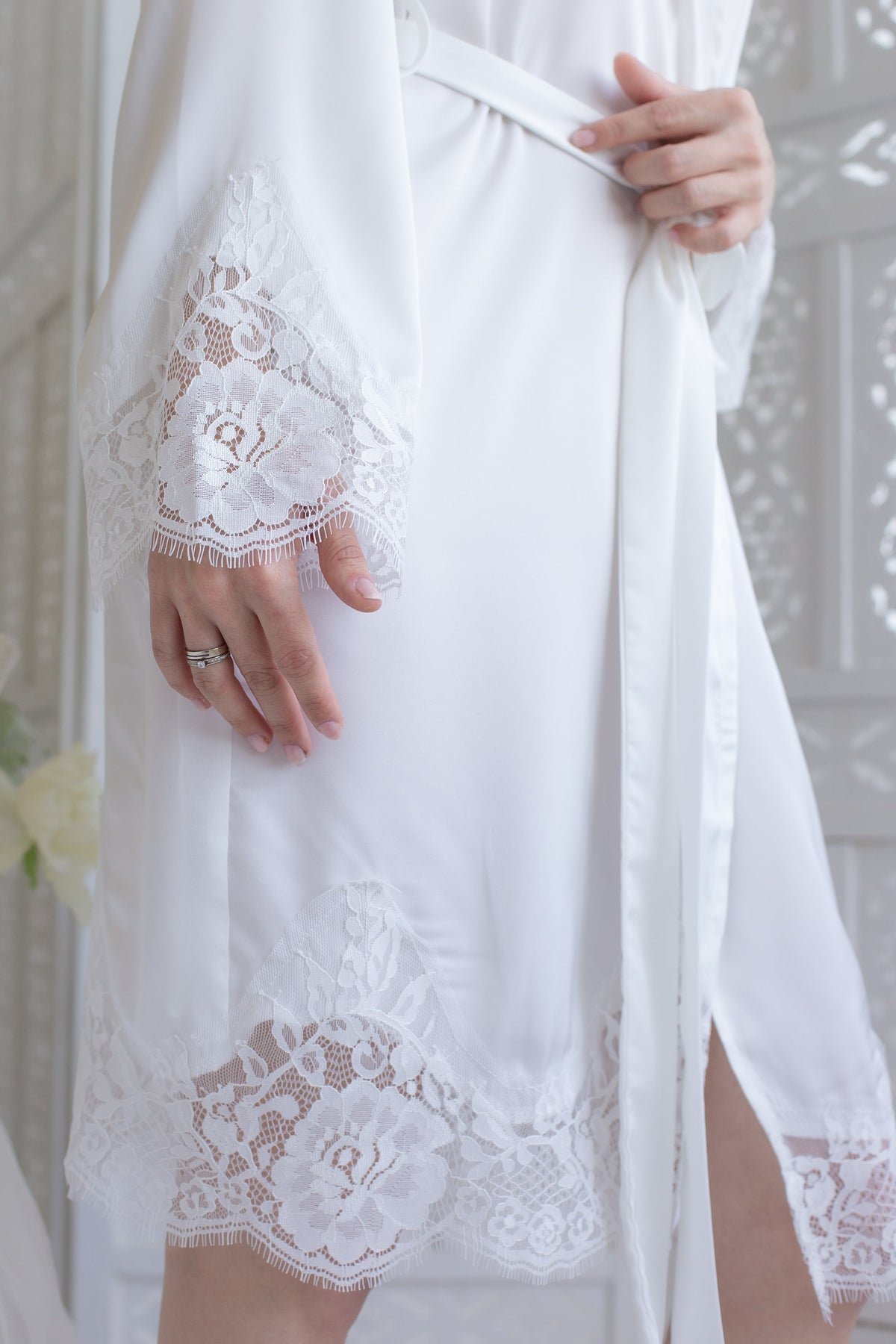 a woman in a white robe holding a white ring