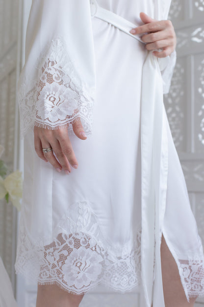 a woman in a white robe holding a white ring