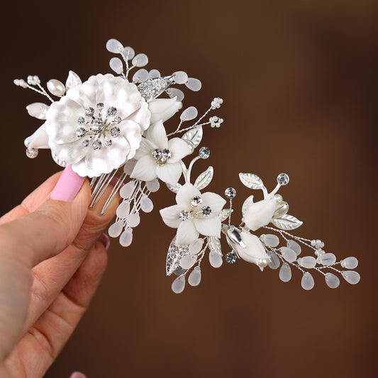 a hand holding a hair comb with flowers on it