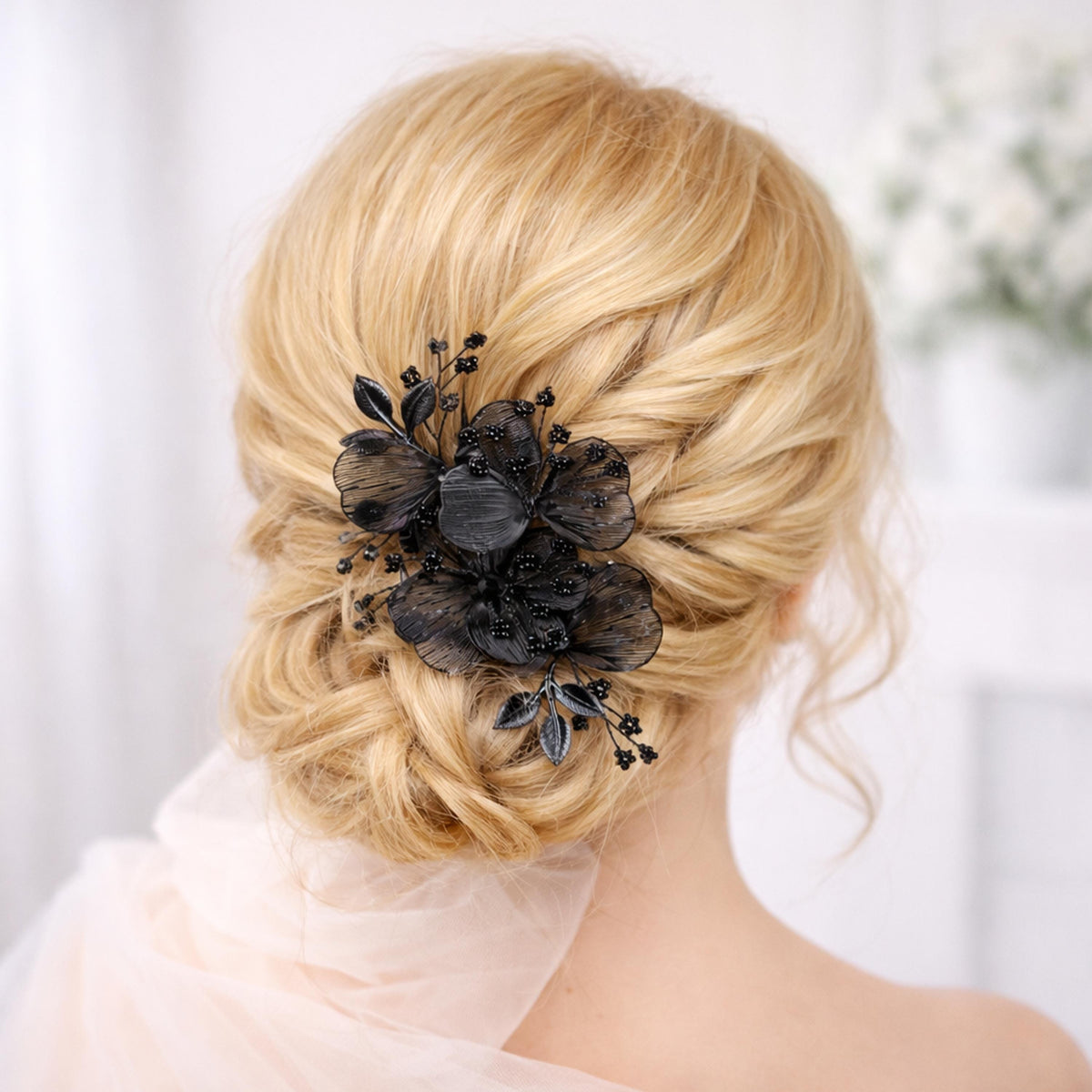 A close-up view of a woman's blonde hair with a black floral hair accessory, such as a flower or flower-shaped hair clip, in the back of her head.