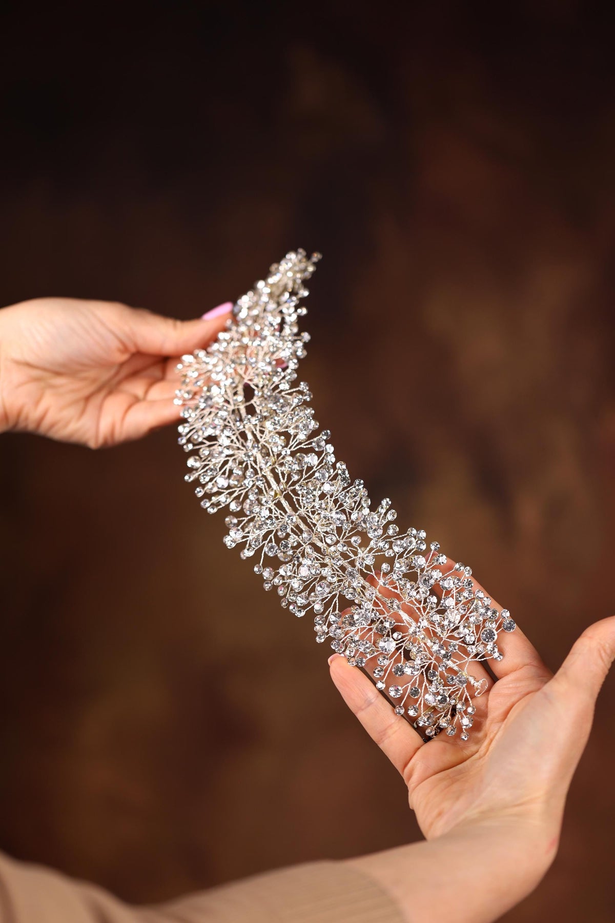 a woman holding a tiara in her hands