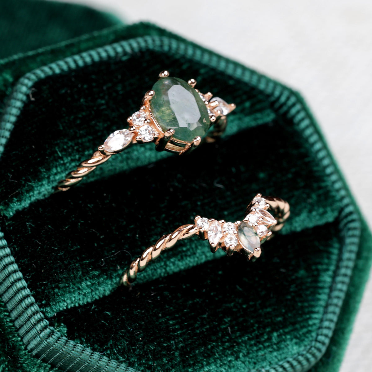 a couple of rings sitting inside of a green velvet box