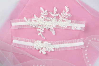 two wedding garters on a pink cloth