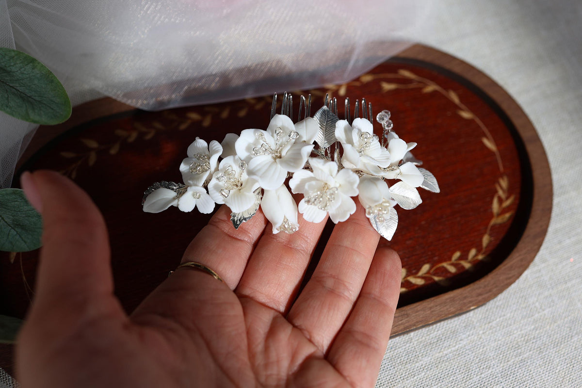 a person holding a fork with white flowers on it