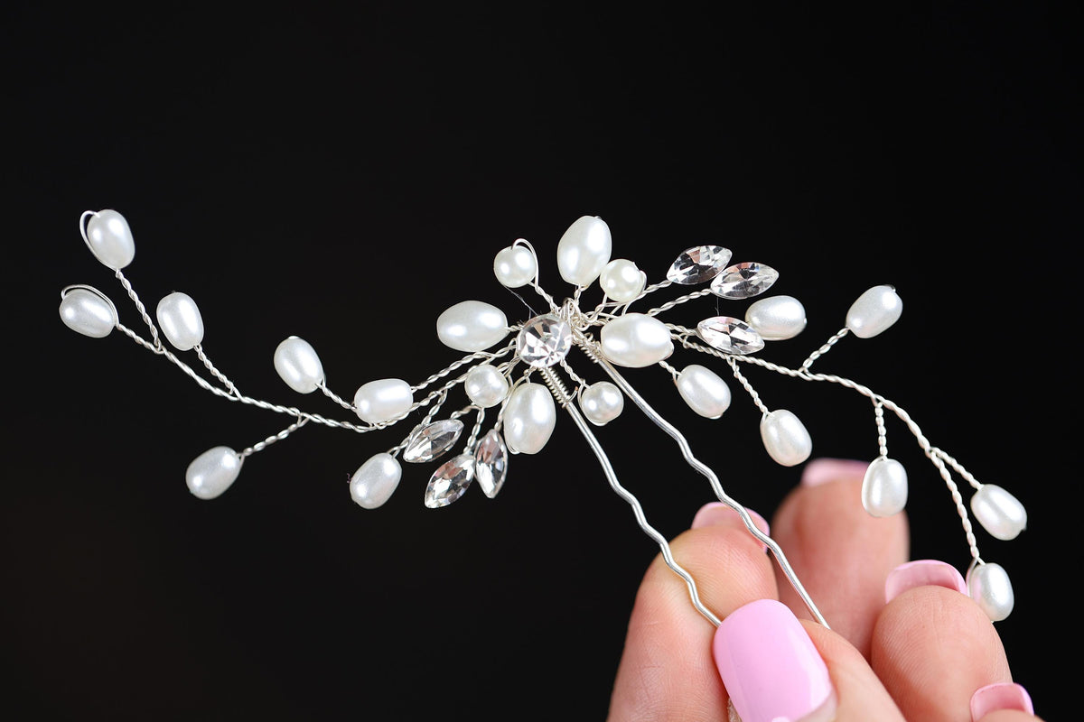 a woman holding a hair comb with pearls on it