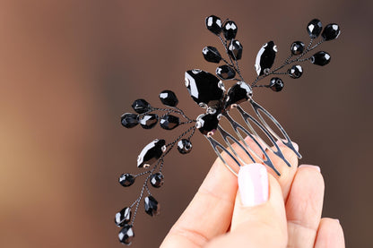 a hand holding a black and white hair comb
