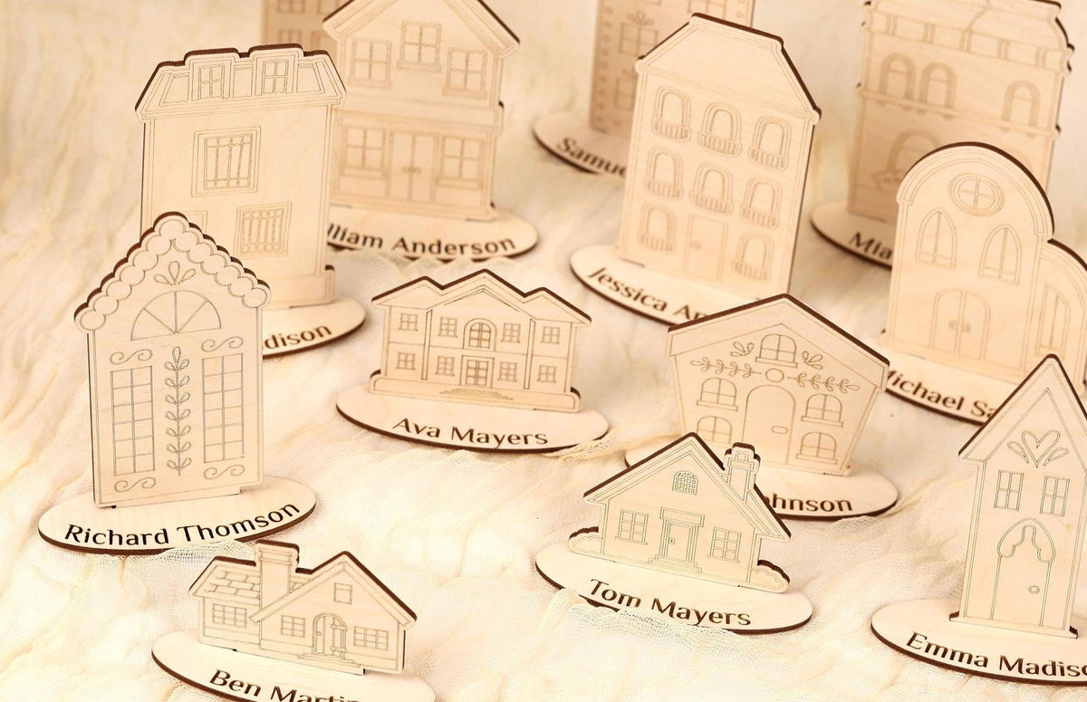 a collection of wooden houses, each with a nameplate, arranged on a white surface.