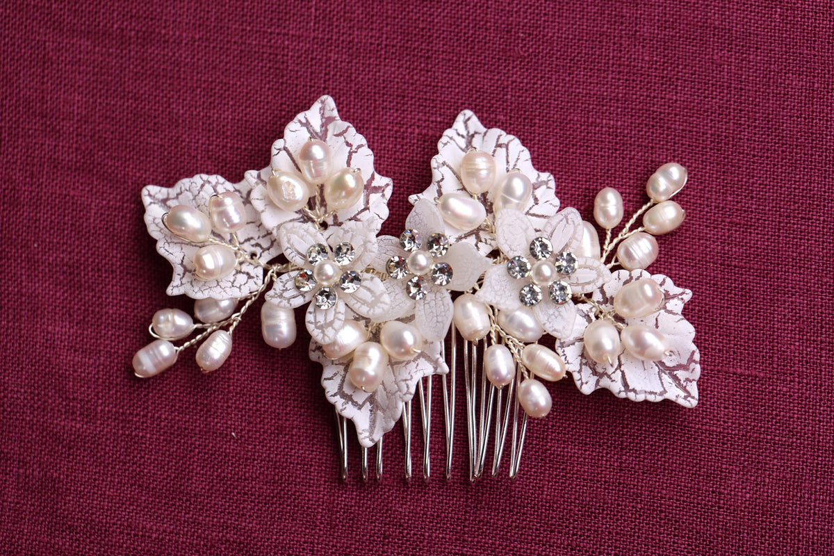 a close up of a hair comb with flowers and pearls
