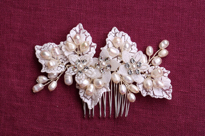a close up of a hair comb with flowers and pearls
