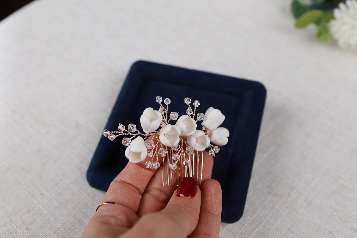 a hand holding a hair comb with flowers on it