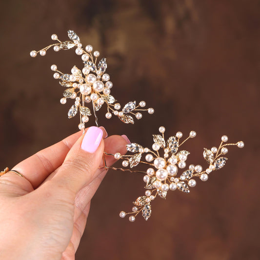 a hand holding a tiara with pearls on it
