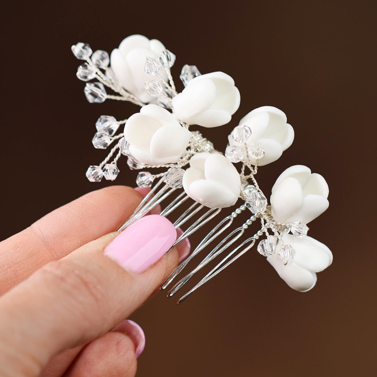 a hand holding a hair comb with flowers on it