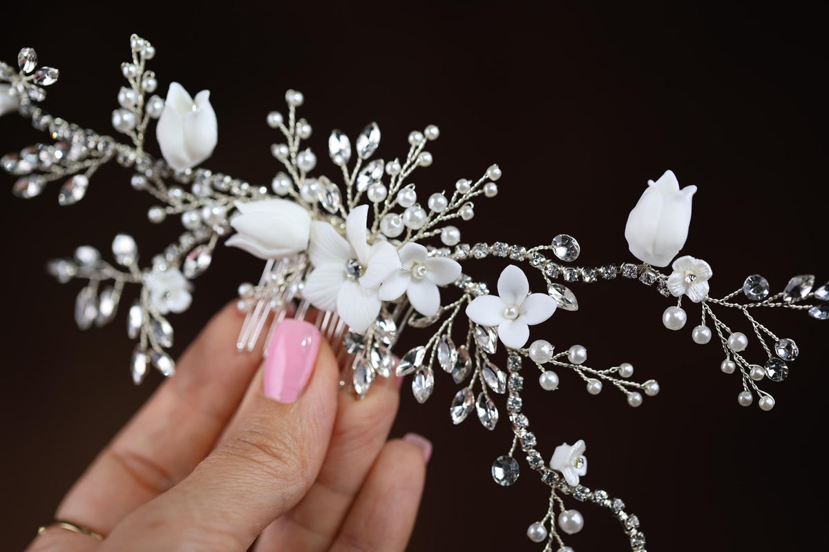 a woman's hand holding a white flower and crystal bridalt