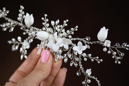 a woman's hand holding a white flower and crystal bridalt