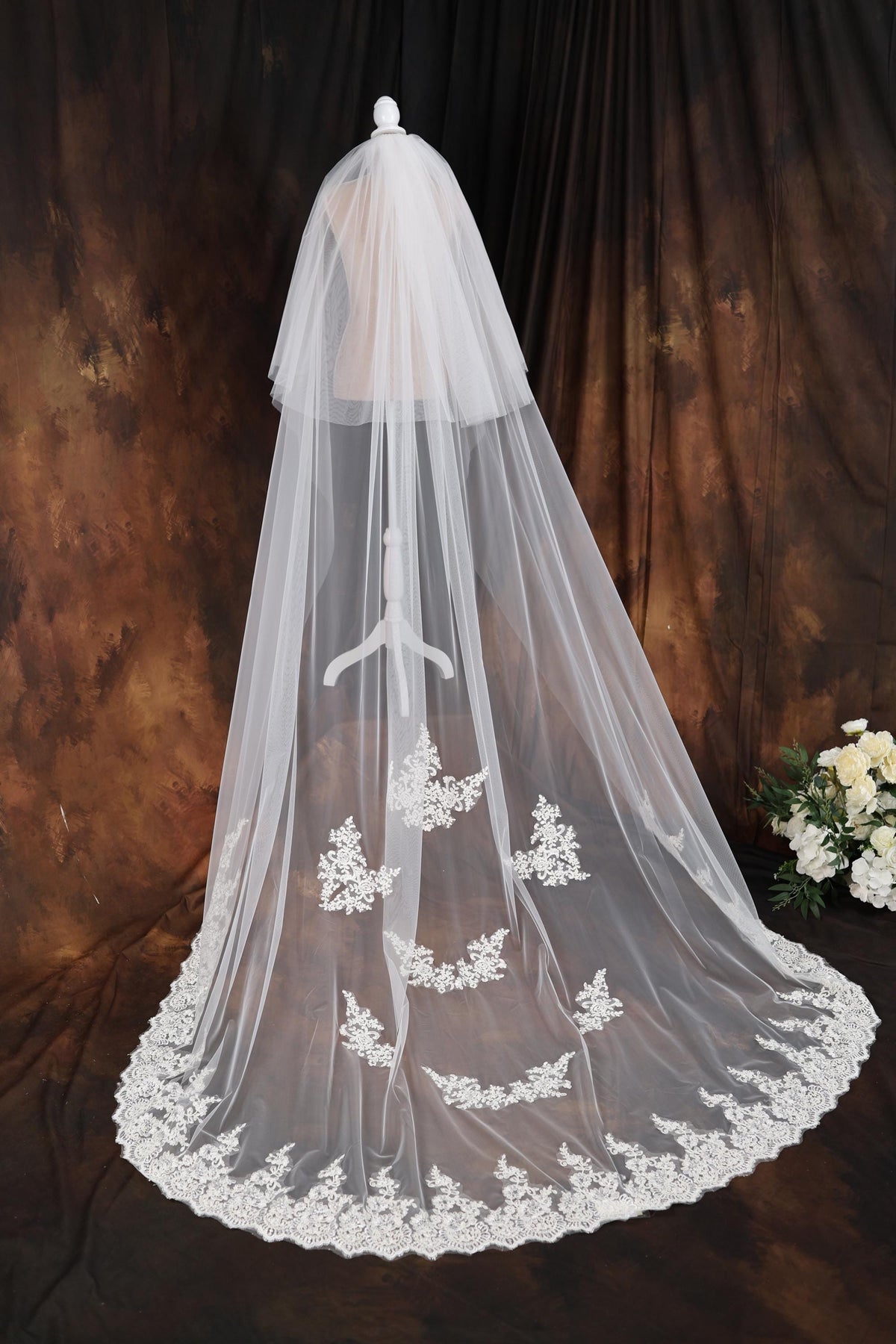 a wedding veil with white flowers on it