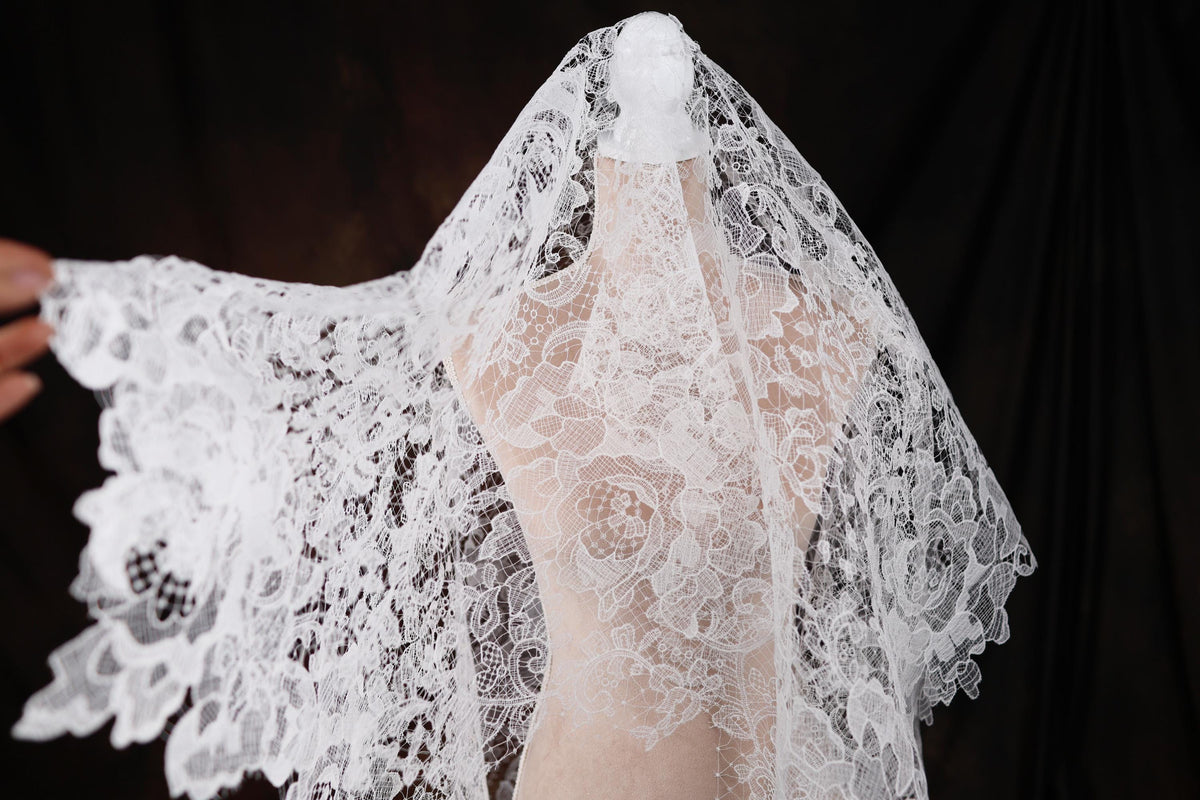 a woman wearing a white veil with white flowers on it