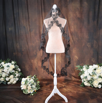 a white mannequin with a black veil and flowers