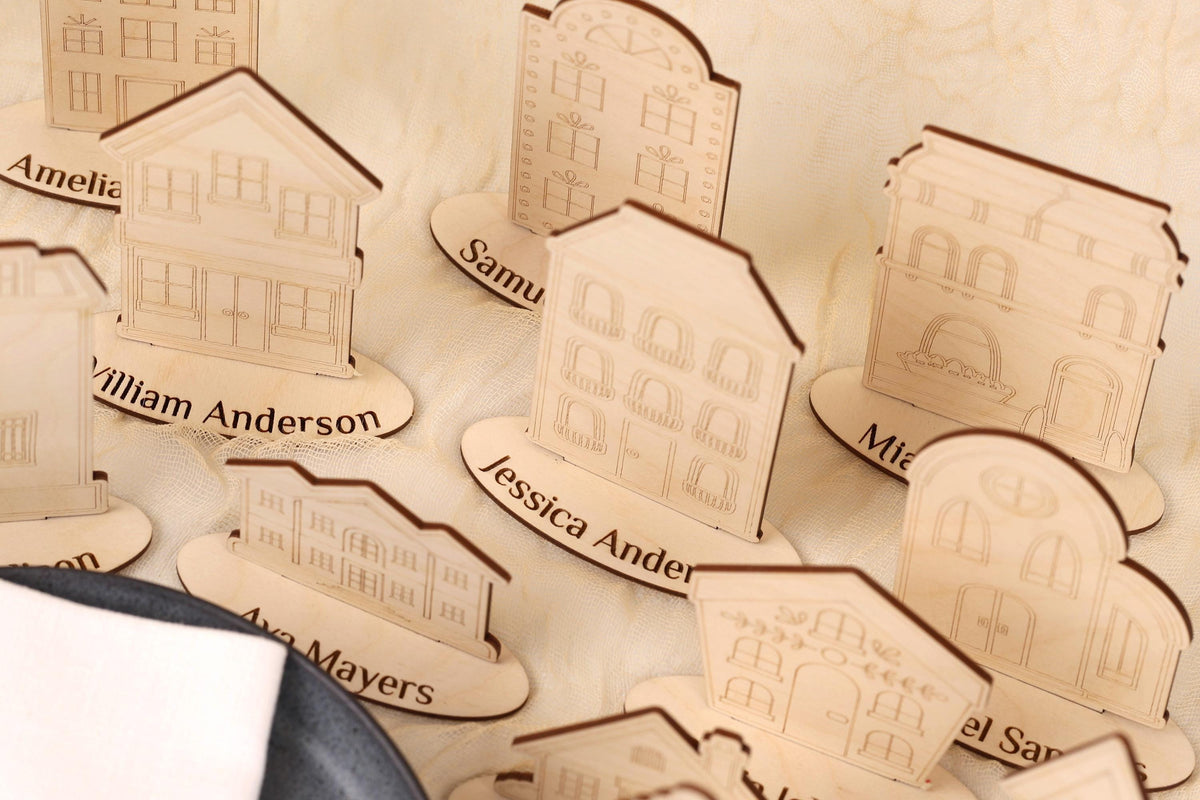 a collection of wooden cutouts of houses, each with a nameplate underneath it. The names on the nameplates include "William Anderson", "Samuel", "Ava Mayers", and "Marian". The wooden cutouts are arranged in a row, creating a visually appealing display.