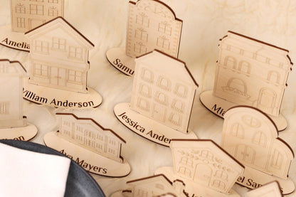 a collection of wooden cutouts of houses, each with a nameplate underneath it. The names on the nameplates include "William Anderson", "Samuel", "Ava Mayers", and "Marian". The wooden cutouts are arranged in a row, creating a visually appealing display.
