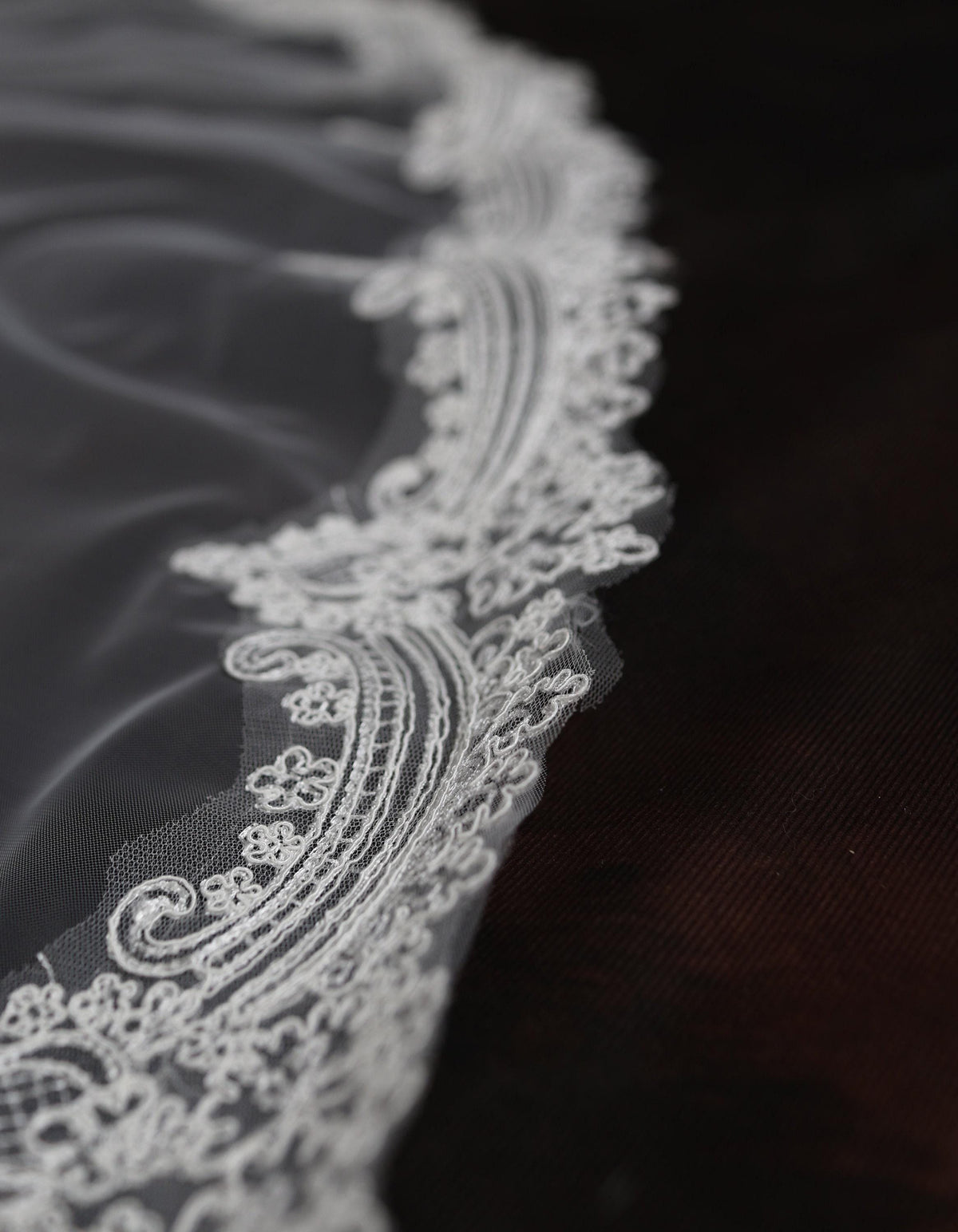 a close up of a white lace on a black cloth