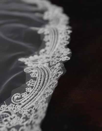 a close up of a white lace on a black cloth