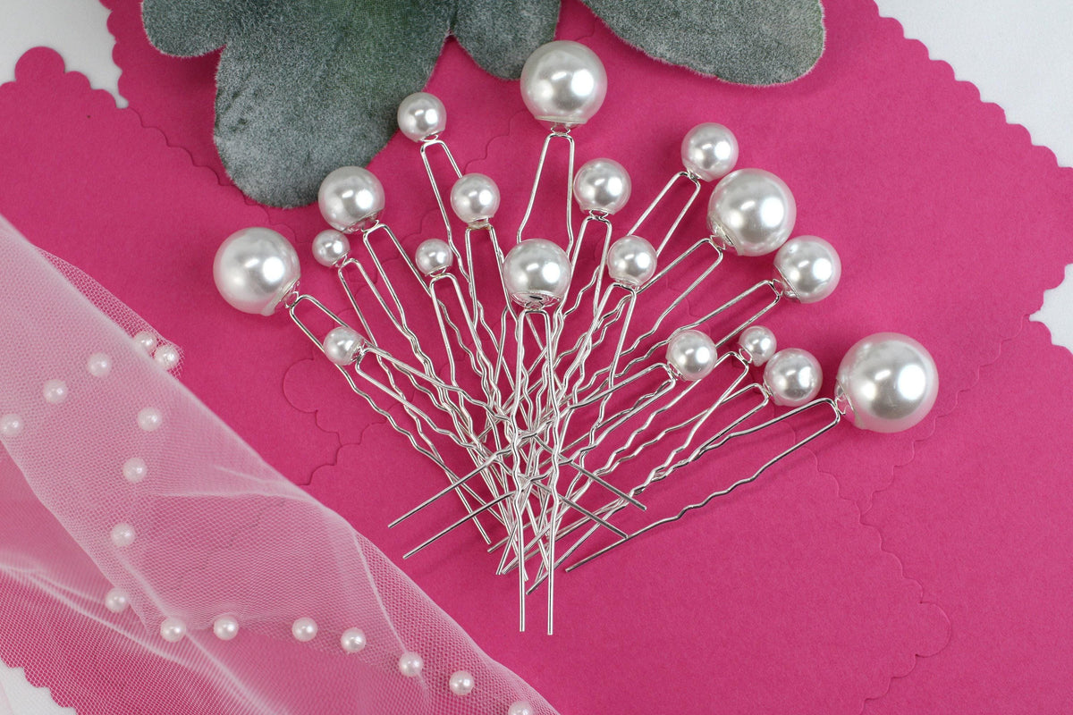 a bunch of pins sitting on top of a pink piece of paper