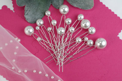a bunch of pins sitting on top of a pink piece of paper