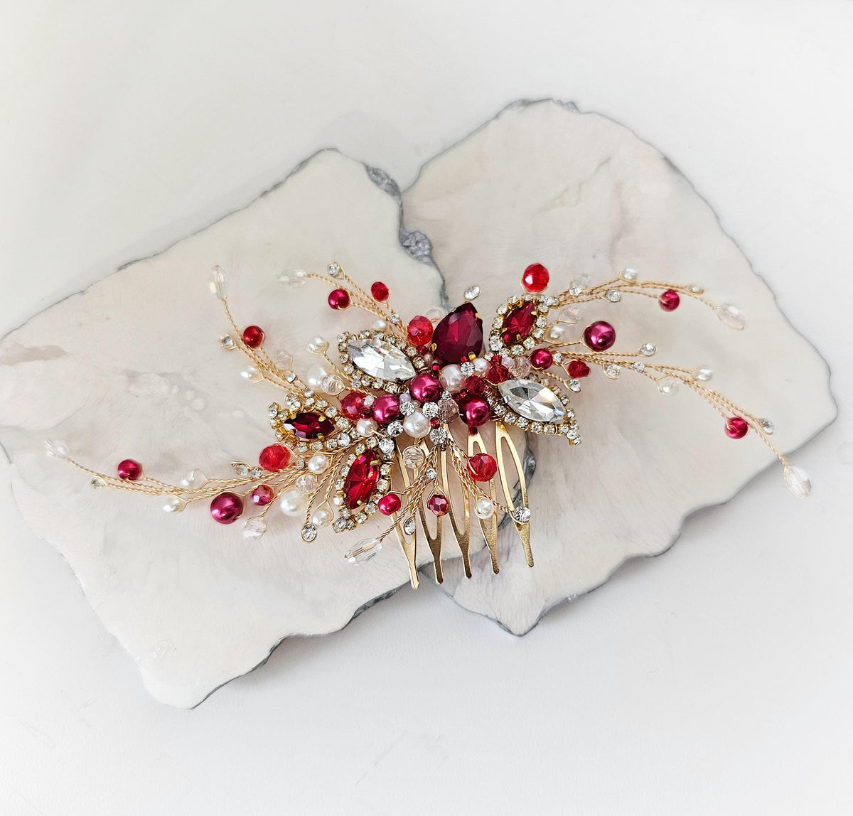 a white plate with a red and gold hair comb on it