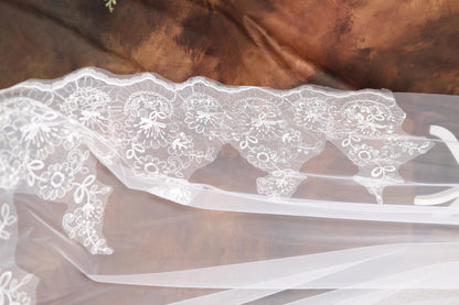 a close up of a wedding veil with flowers on it