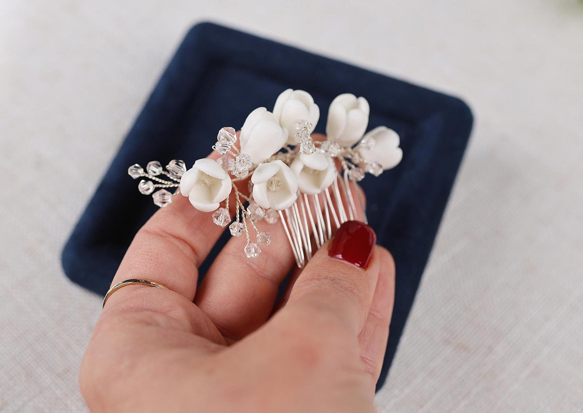 a woman is holding a comb with flowers on it