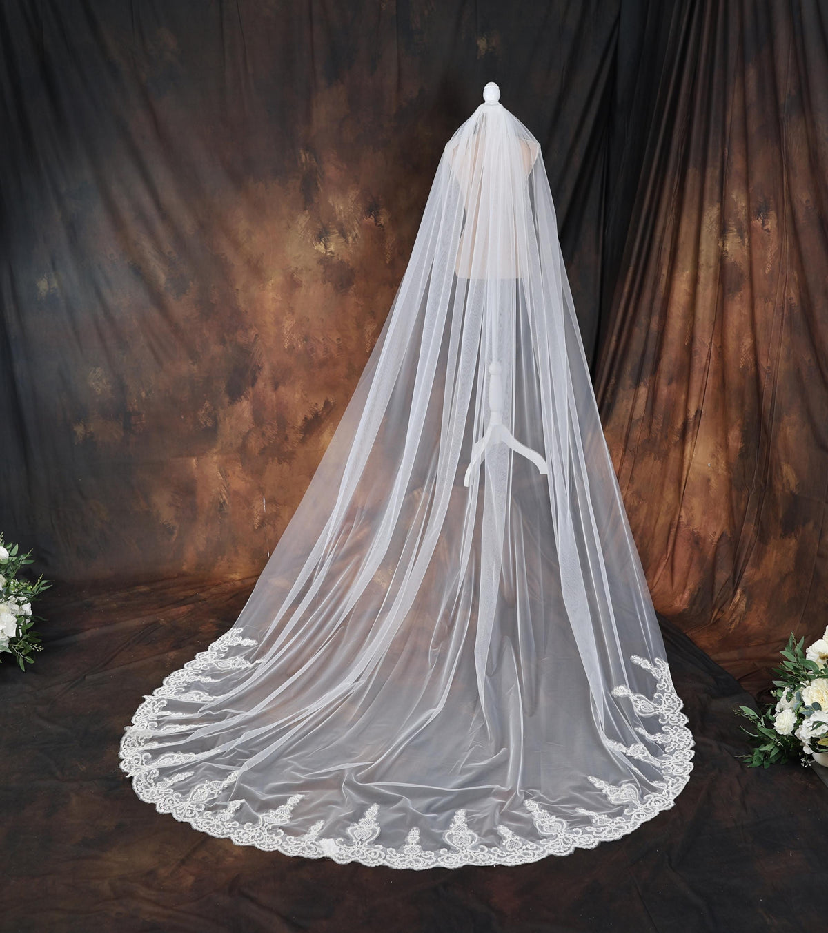 a bridal veil with white flowers on a table