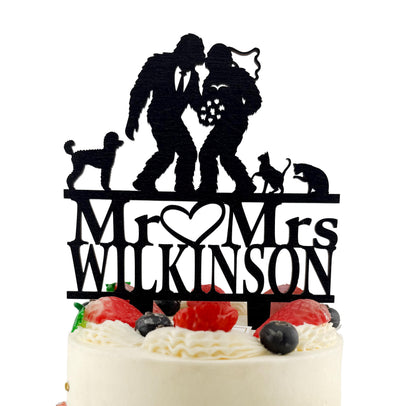 A black silhouette of a bride and groom on top of a cake, with the words "Mr. Wilton" written below them.