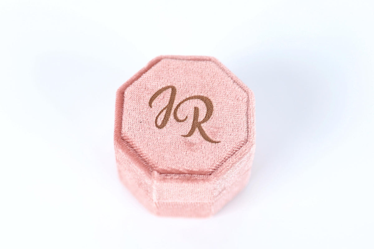 A pink velvet box with the initials "JR" printed on it.
