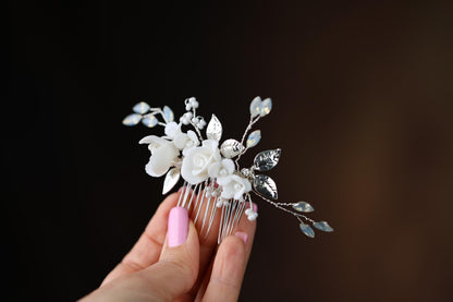 a woman's hand holding a hair comb with flowers on it