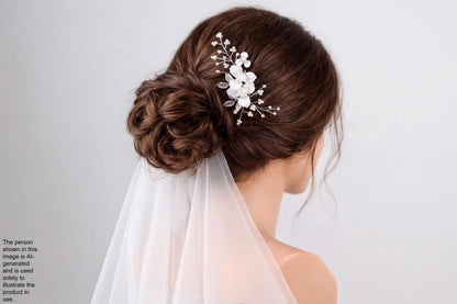 A woman with her hair styled in a bun, wearing a veil and a decorative hair accessory.