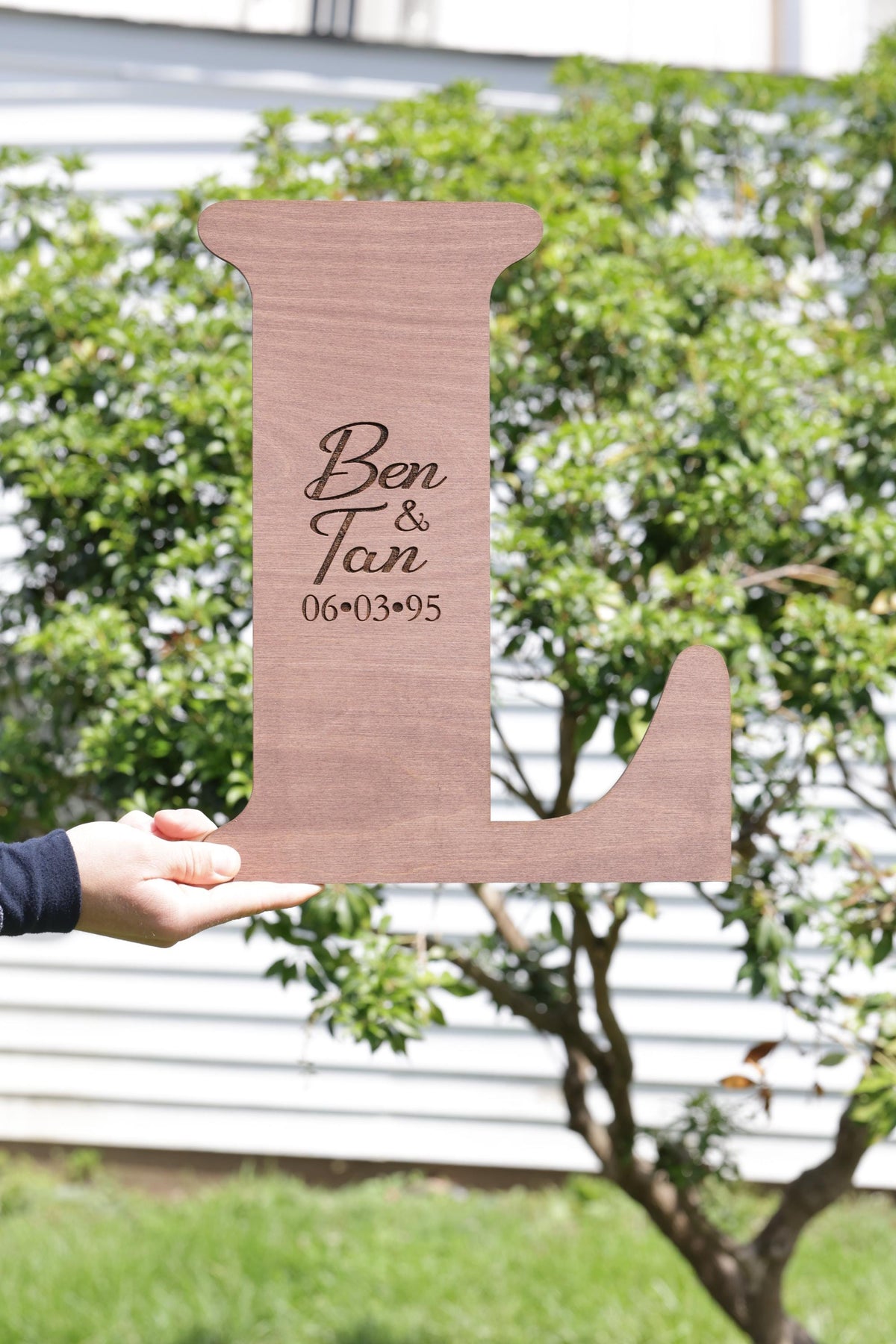 a person holding a cardboard cut out of a dog bone