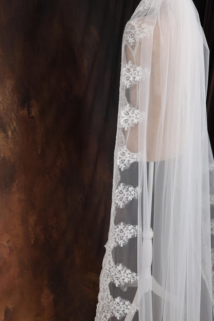 a woman wearing a white veil and a white dress