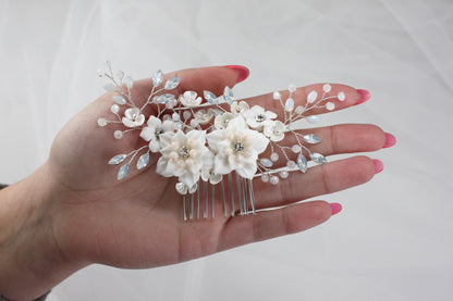 a woman's hand holding a hair comb with flowers on it