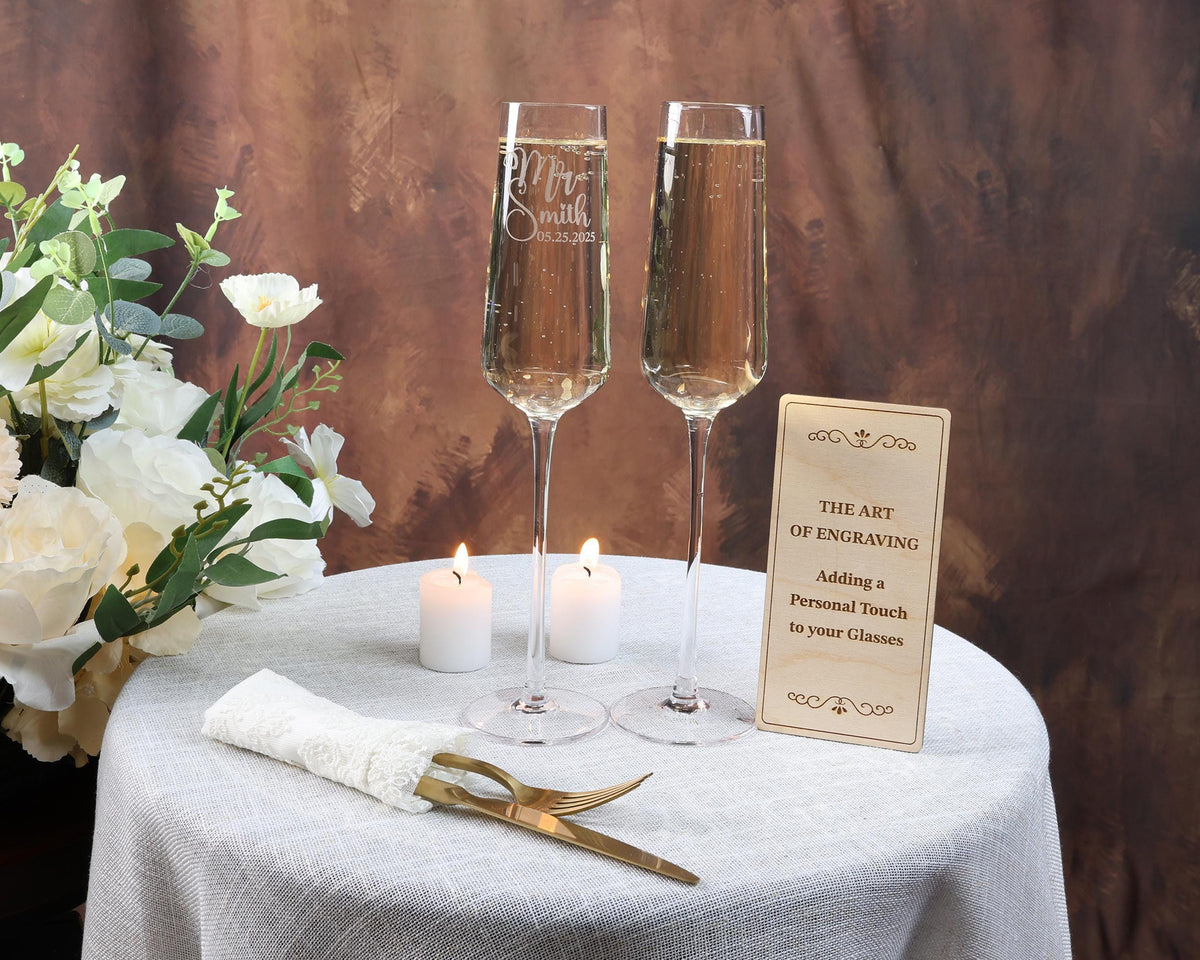 two glasses of champagne sitting on a table with a sign