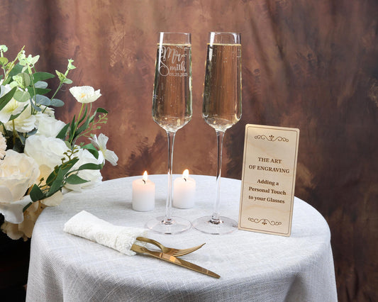 two glasses of champagne sitting on a table with a sign