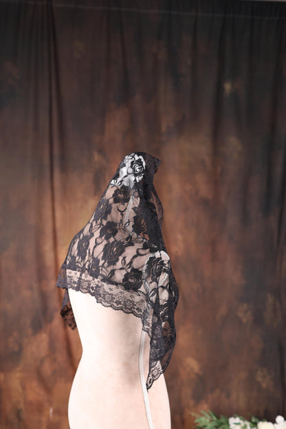 a mannequin with a black lace hat on top of it