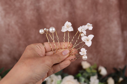a person holding a piece of wire with flowers on it